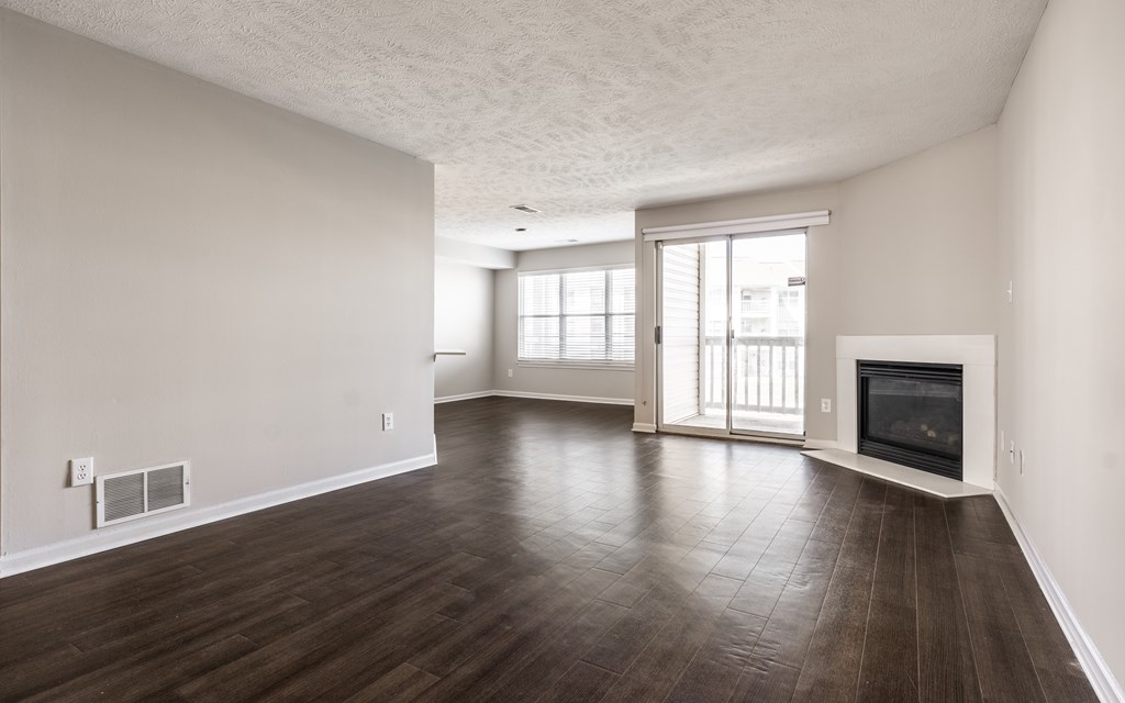 A spacious living room with wood flooring and a fireplace at Mallard Bay Apartments, Crown Point, Indiana