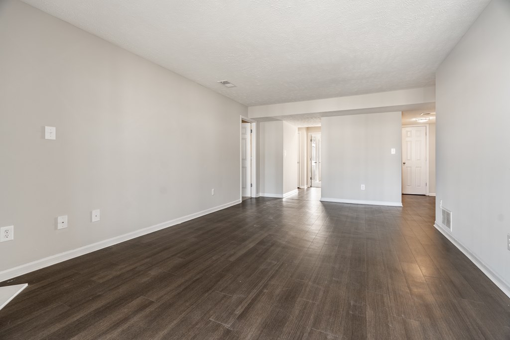 A large empty room with wooden flooring and white walls at Mallard Bay Apartments, Crown Point, Indiana