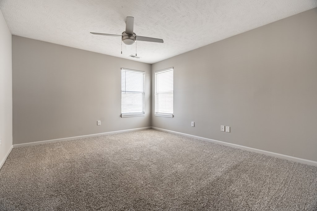 A room with a ceiling fan and carpeted floor at Mallard Bay Apartments, Crown Point, Indiana
