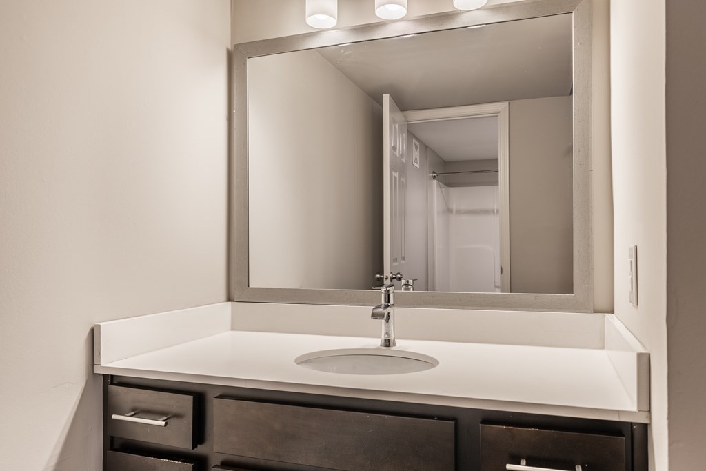 A bathroom sink with a large mirror above it at Mallard Bay Apartments, Crown Point, Indiana