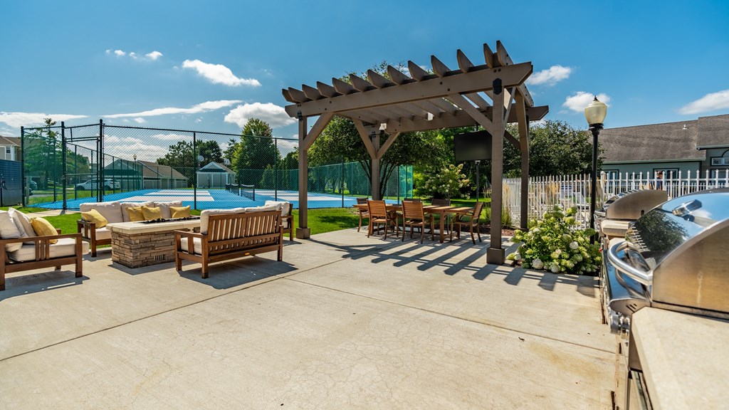 A sunny day at the poolside with a wooden pergola and lounge chairs at Mallard Bay Apartments, Crown Point, Indiana