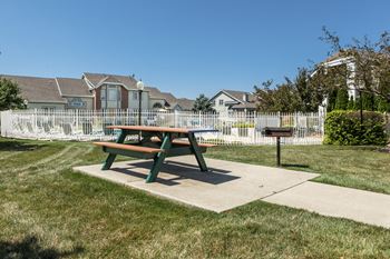 A green picnic table sits in the middle of a grassy area at Mallard Bay Apartments, Crown Point, Indiana