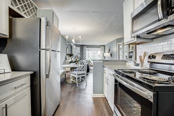 A kitchen with a black refrigerator and stove at Mallard Bay Apartments, Crown Point