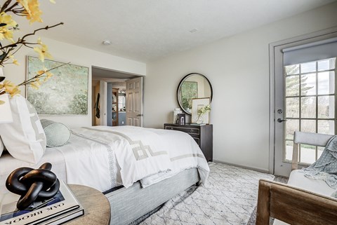 A bedroom with a large bed and a round mirror on the wall. A bedroom with a large bed and a round mirror on the wall at Mallard Bay Apartments, Indiana