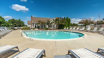A large outdoor swimming pool surrounded by sun loungers