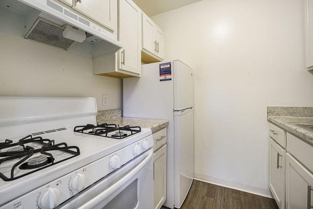 a white kitchen with hard surface flooring at Newport Village Apartments, Portage, MI