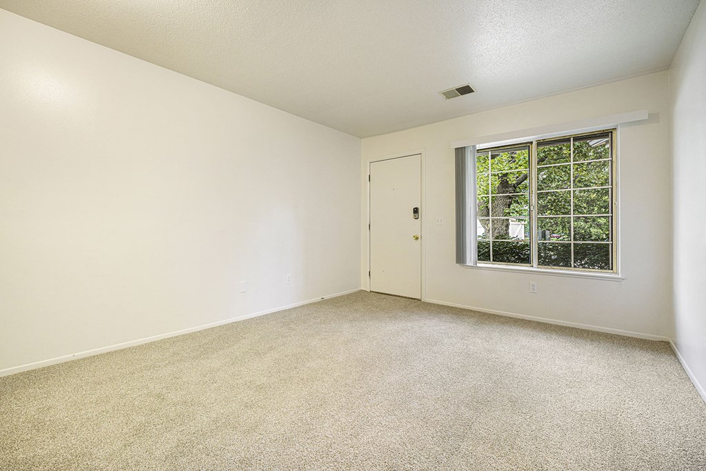 Main floor living with a large window at Newport Village Apartments, Portage, MI