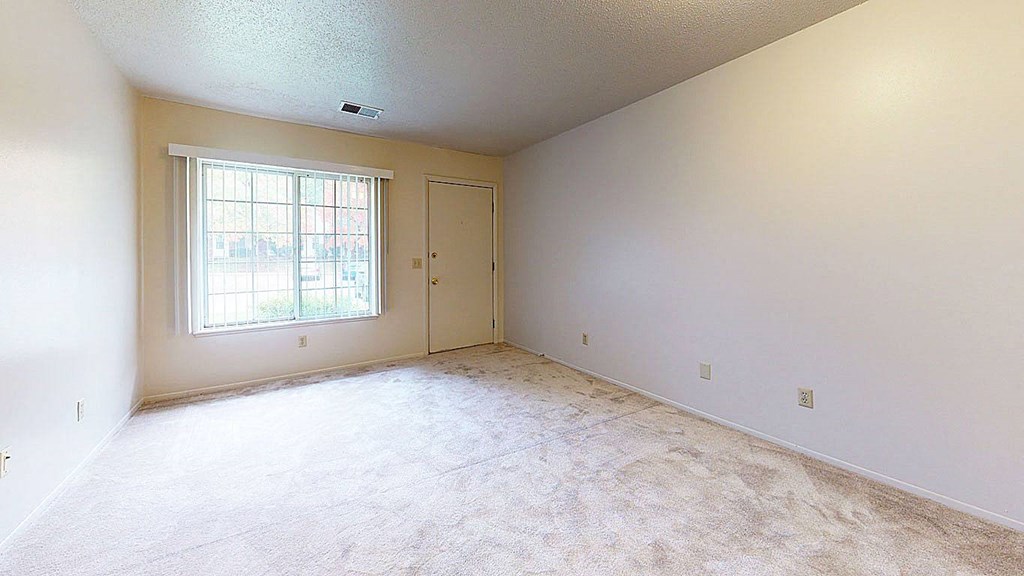 living room with large windows and plush carpeting at Newport Village Apartments, Portage