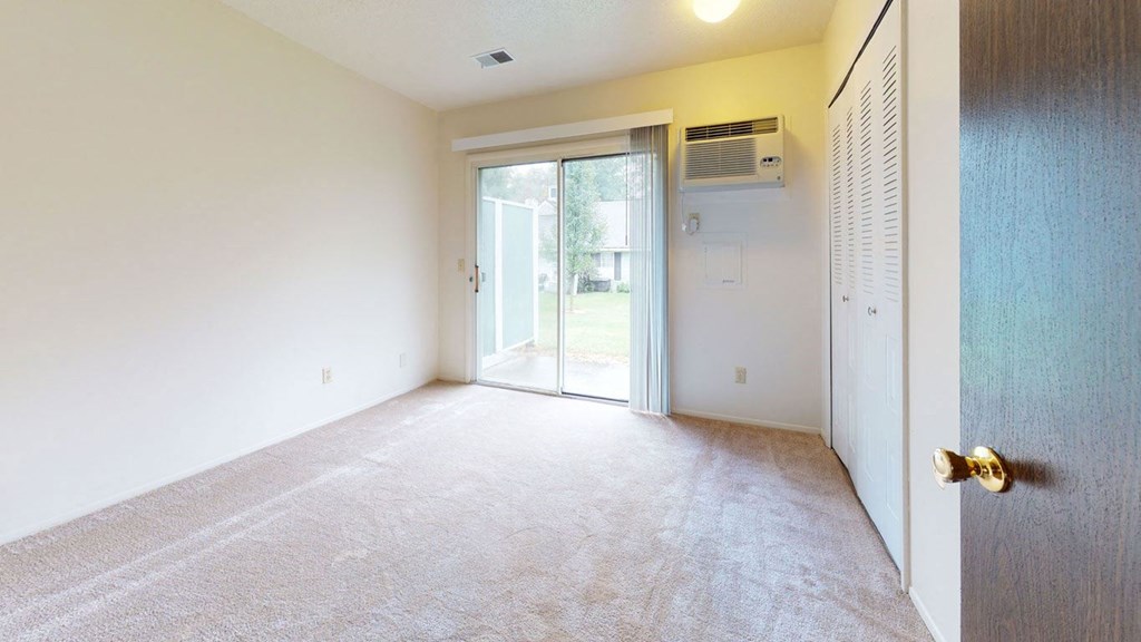 living room with a closet and a door to a patio at Newport Village Apartments, Portage
