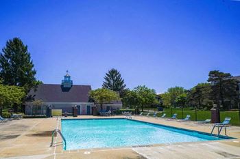 a swimming pool with a house in the background at Newport Village Apartments in Portage, MI 49002