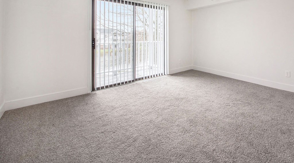 Living room with a sliding glass door at North Pointe Apartments in Elkhart, IN