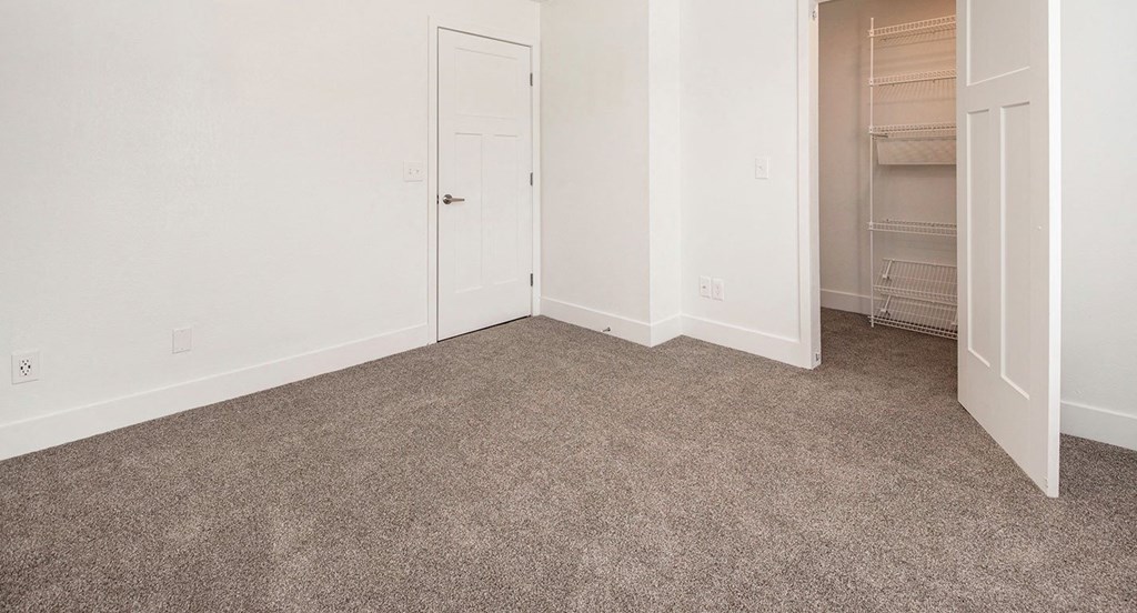 Bedroom with carpet and a walk-in closet at North Pointe Apartments in Elkhart, IN