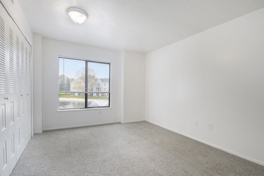 bedroom with a large window and carpet at North Pointe Apartments in Elkhart, IN