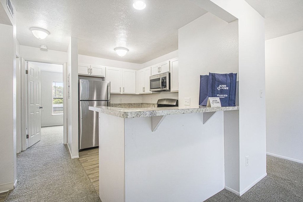 a kitchen with a breakfast bar at North Pointe Apartments in Elkhart, IN