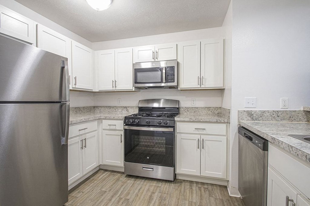 a kitchen with stainless steel appliances and white cabinets at North Pointe Apartments in Elkhart, IN