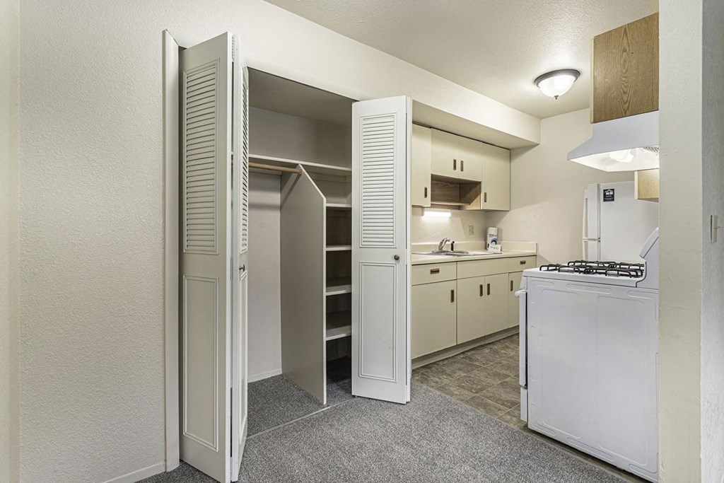 a kitchen with white appliances and a closet at Normandy Village Apartments, Michigan City