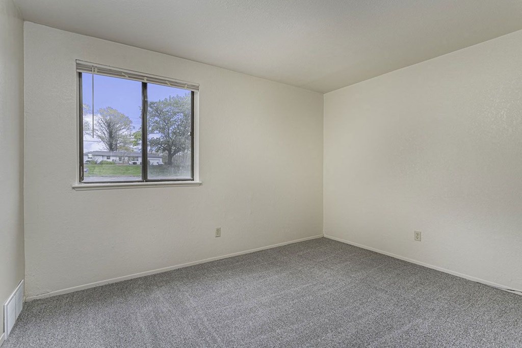 Large bedoom with a window and carpeting at Normandy Village Apartments, Michigan City, IN