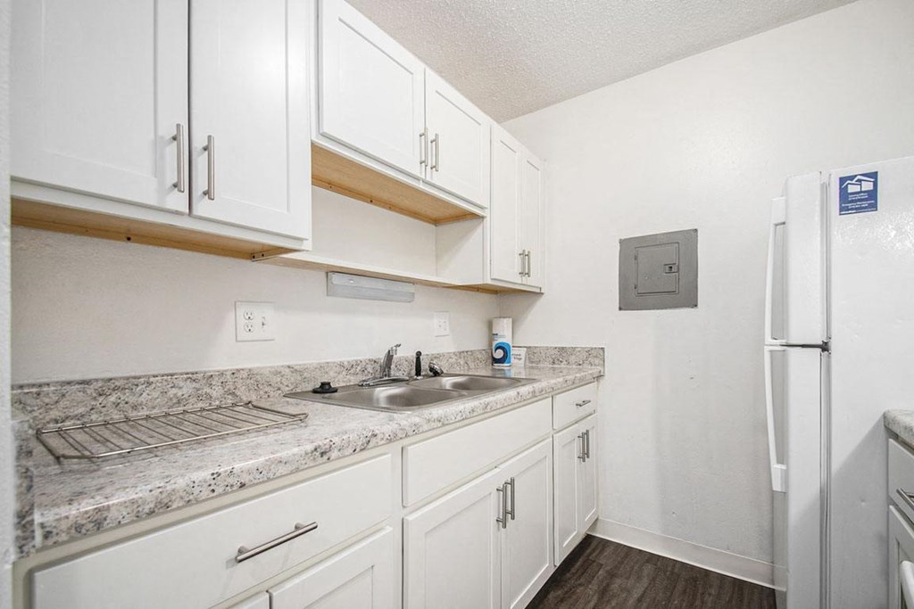 an upgraded kitchen with white cabinets and a sink and a refrigerator at Normandy Village Apartments, Michigan City, IN
