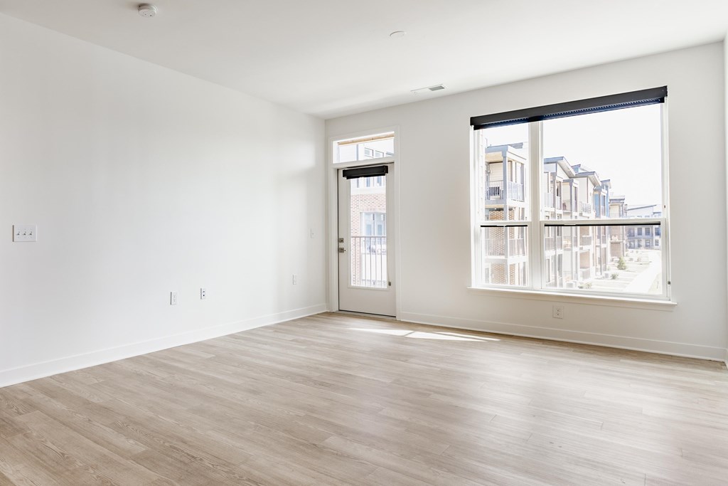 A large empty room with a view of a cityscape through the window