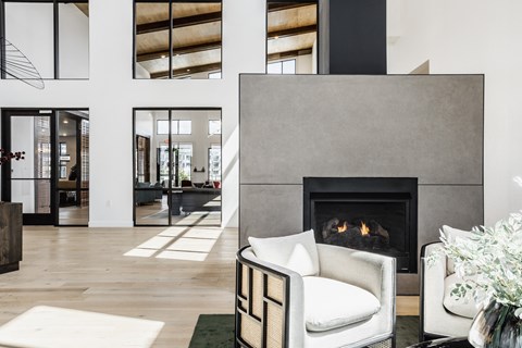 a living room with a white chair and a fireplace