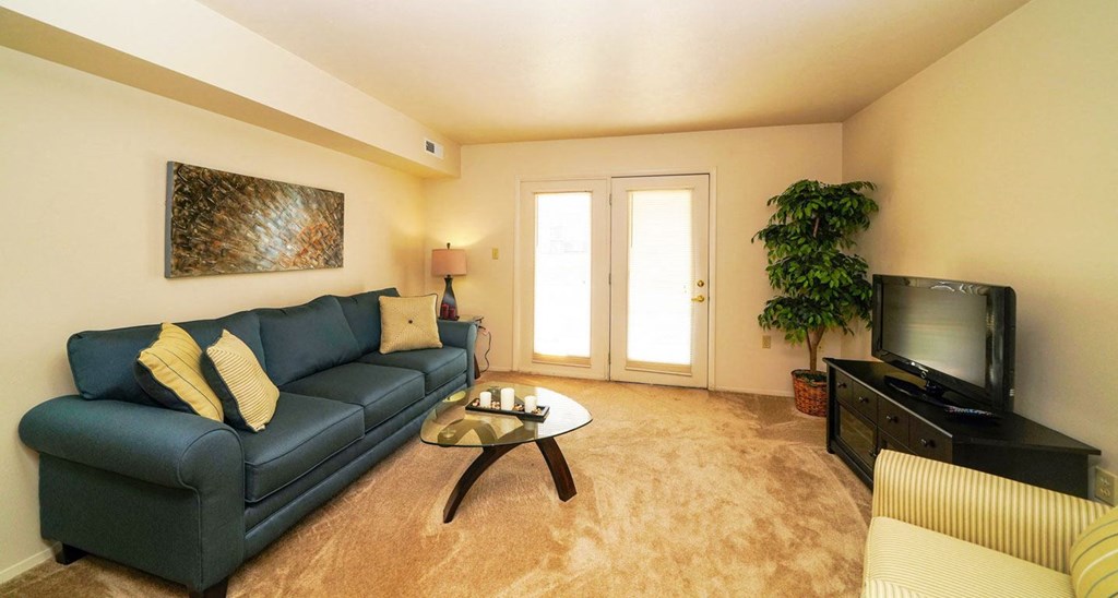 Spacious Living Room Leads To Private Patio at Oak Shores Apartments in Oak Creek, WI