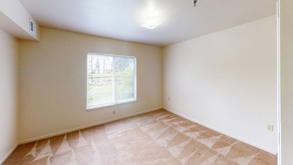 spacious bedroom with a large window at Orchard Lakes Apartments in Toledo, Ohio