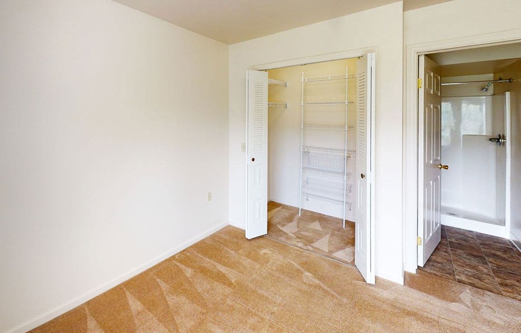 Master bedroom with a large closet and attached second bath at Orchard Lakes Apartments in Toledo, Ohio