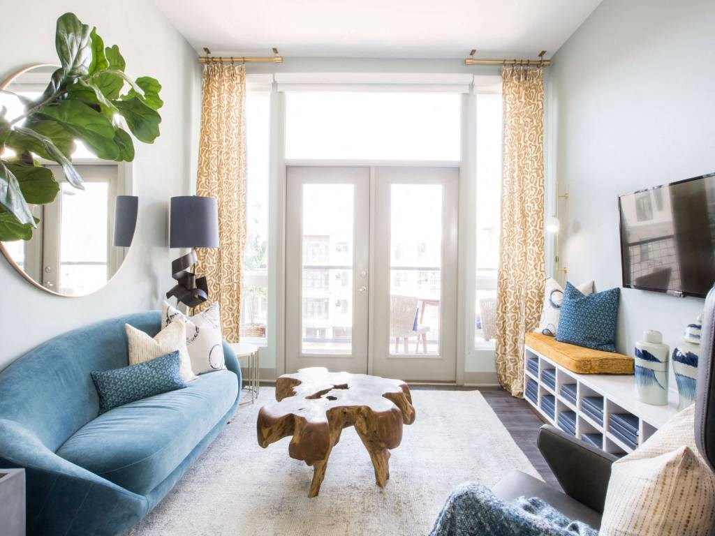 a living room with a blue couch and a large window  at Avant & Avant II, Carmel, IN, 46032