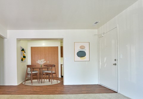 a dining room with a wooden table and a door to a kitchen