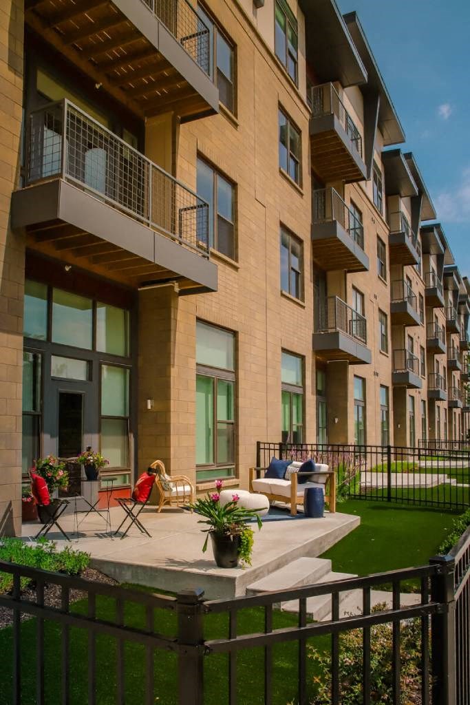 a patio with chairs and a couch in front of an apartment building  at Avant & Avant II, Carmel, Indiana