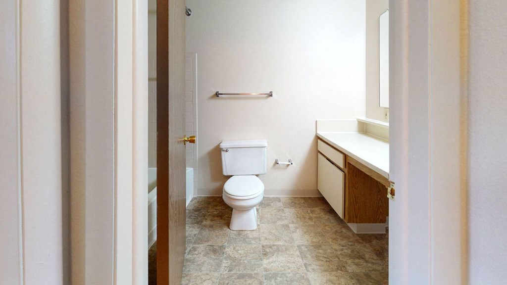 a bathroom with a toilet and a sink at Pine Knoll Apartments, Battle Creek, 49014