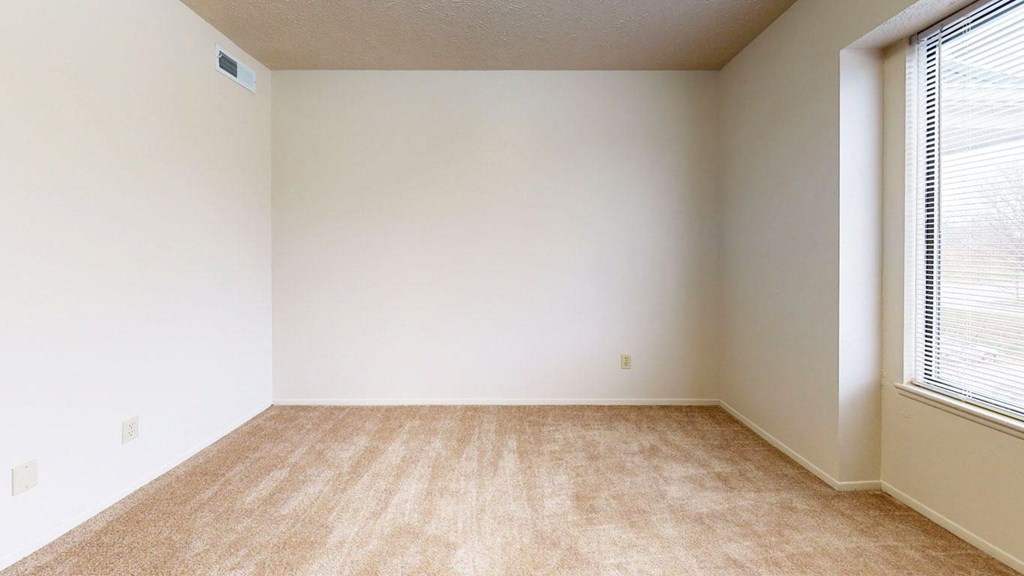 bedroom with a window and plush carpeting at Pine Knoll Apartments, Battle Creek, 49014