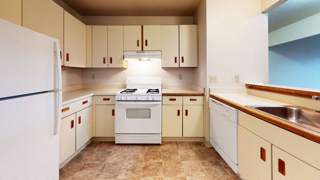 a kitchen with white cabinets and a stove and a refrigerator at Pine Knoll Apartments, Battle Creek, 49014