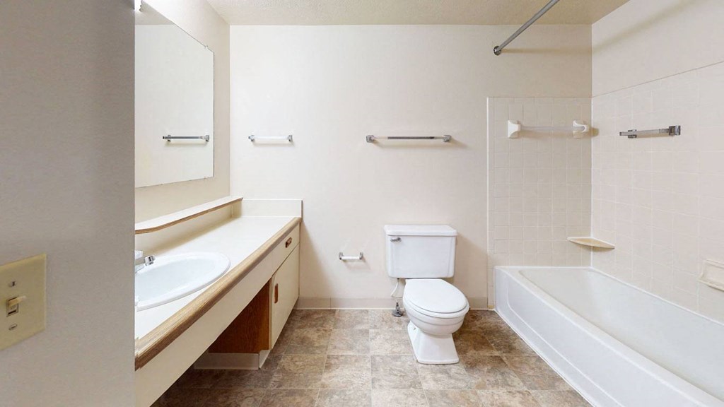 main bathroom with a toilet and a sink and a bath tub at Pine Knoll Apartments, Battle Creek, 49014