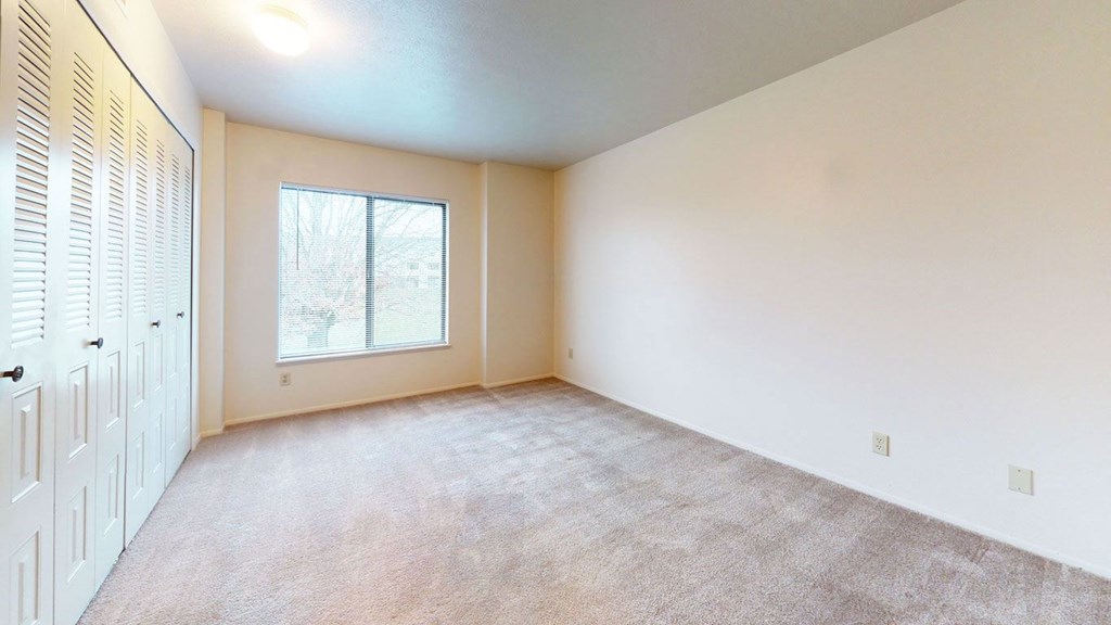 spacious bedroom with a large window and closet at Pine Knoll Apartments, Battle Creek, 49014
