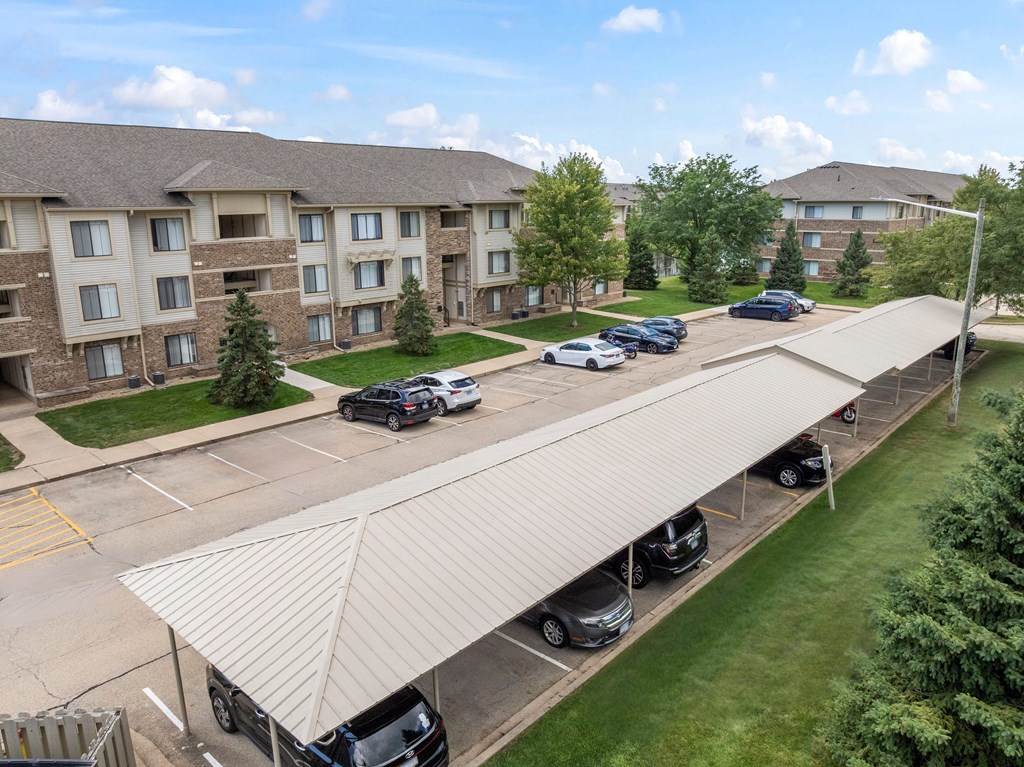 A parking lot with cars and a building in the background.