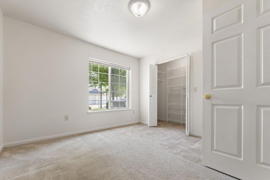 spacious bedroom with a walk in closet and a window at Hunters Pond Apartment Homes, Champaign, IL