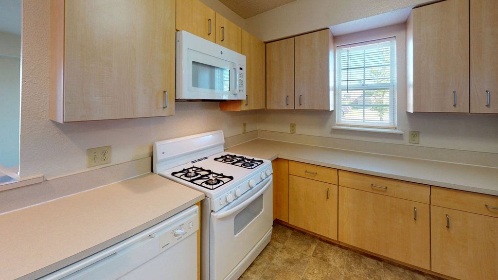 End style kitchen with white appliances and wooden cabinets  at Hunters Pond Apartment Homes, Champaign, 61820