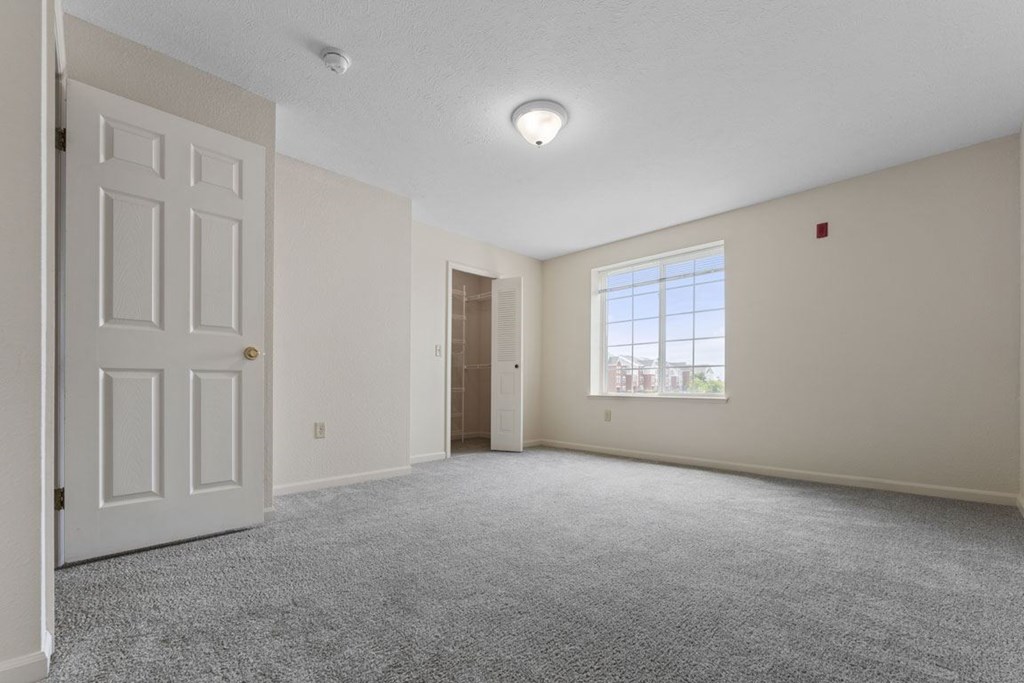 large bedroom with a ceiling fan and a door to a walk-in closet  at Hunters Pond Apartment Homes, Champaign, Illinois