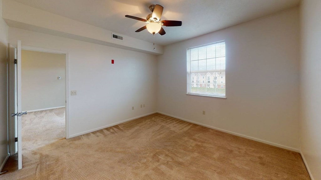 an empty bedroom with a ceiling fan and a window  at Hunters Pond Apartment Homes, Champaign, IL, 61820