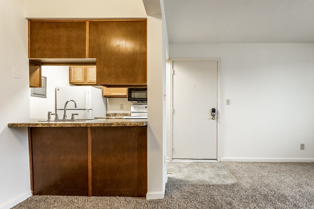 an empty kitchen with a counter and a door to a room at Pheasant Run Apartments, Lafayette, IN, 47909
