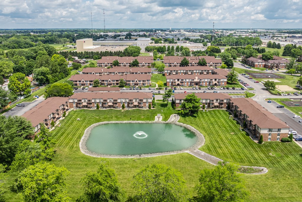 A large building complex with a green field in front