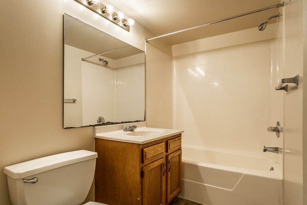a bathroom with a toilet sink and mirror at Pheasant Run Apartments, Lafayette, Indiana
