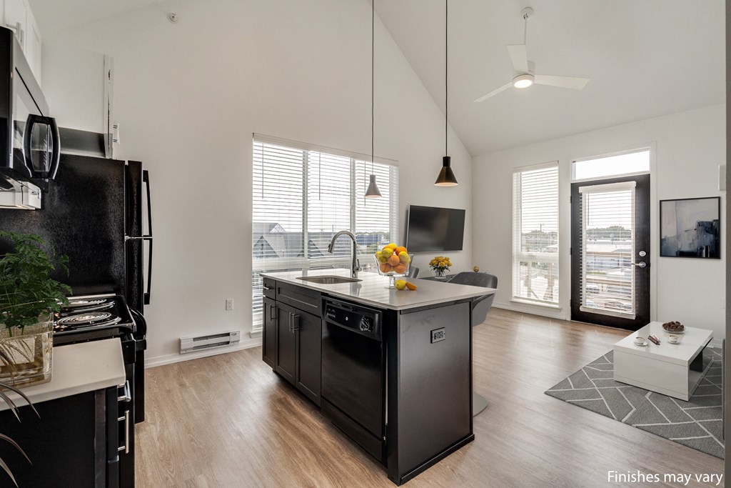 a kitchen with a large island and a view of a living room  at Uptown Square Apartments, Troy, MI