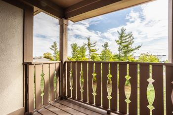 a balcony with a view of a blue sky and trees at Polo Run Apartments, Greenwood, 46142