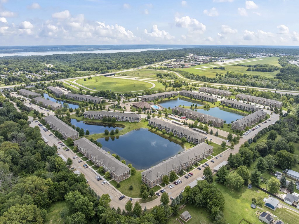 A bird's eye view of a residential area with a lake in the middle.