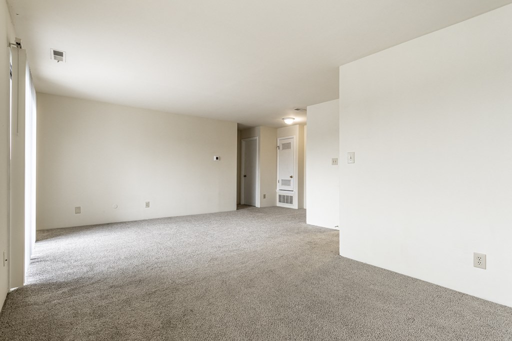 an empty living room with white walls and carpet at Scarborough Lake Apartments, Indiana, 46254