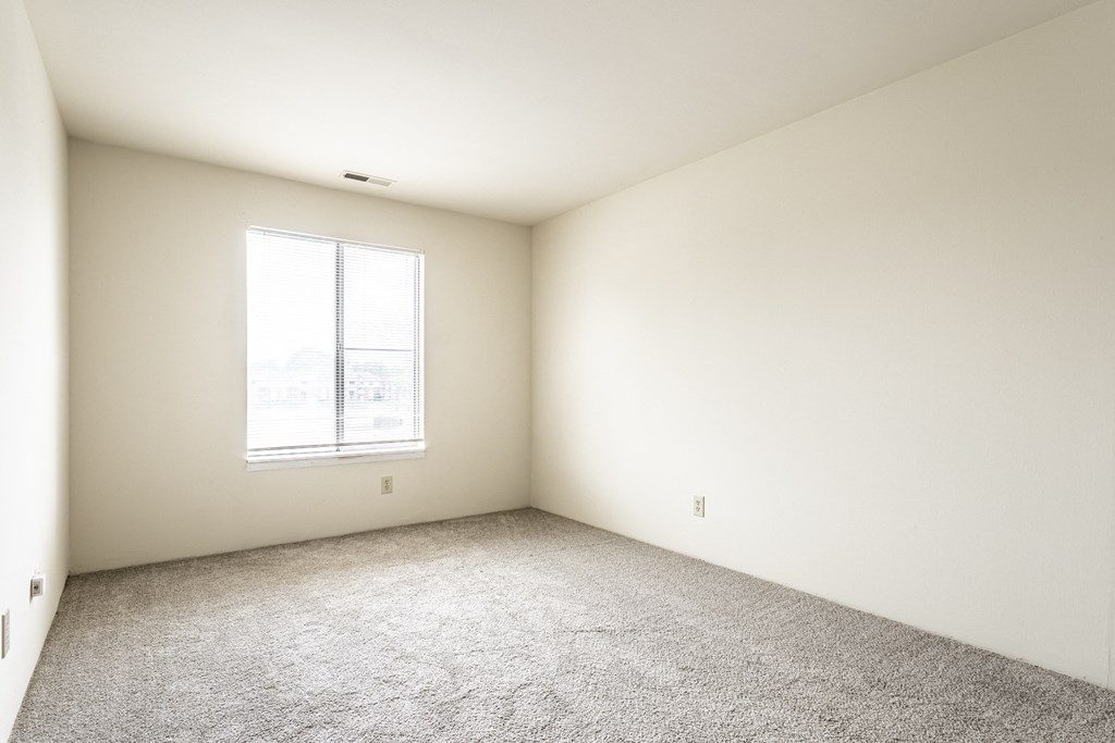 an empty room with carpet and a window at Scarborough Lake Apartments, Indianapolis, IN