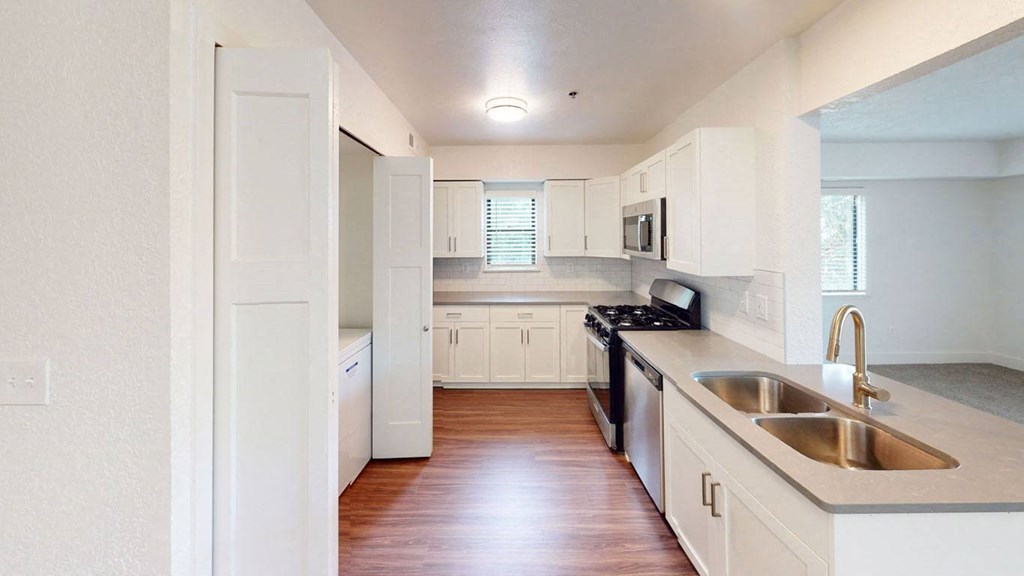 an empty kitchen with white cabinets and a sink at Green Ridge Apartments, Grand Rapids, 49544