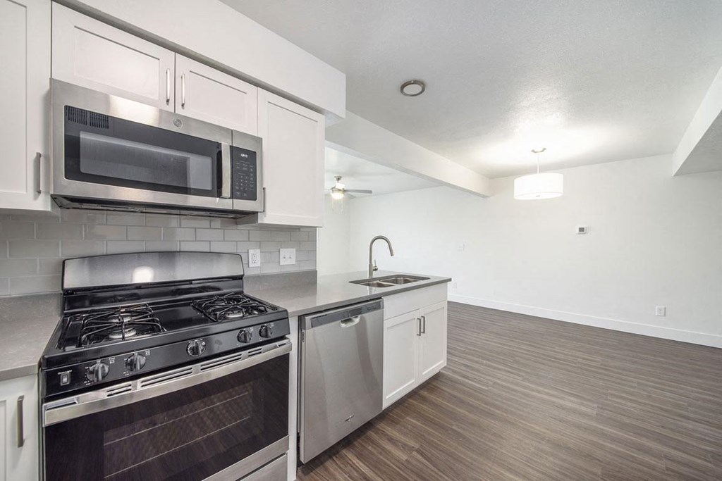 a kitchen with a stove top oven next to a sink at Green Ridge Apartments, Grand Rapids, MI